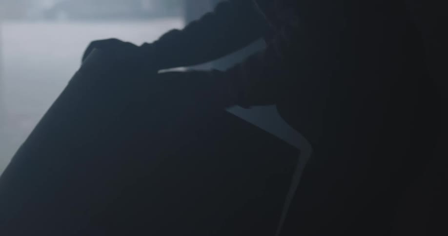 A person with gloves rolling a barrel