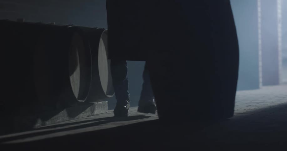 Person rolling a barrel is silhouetted against the door light