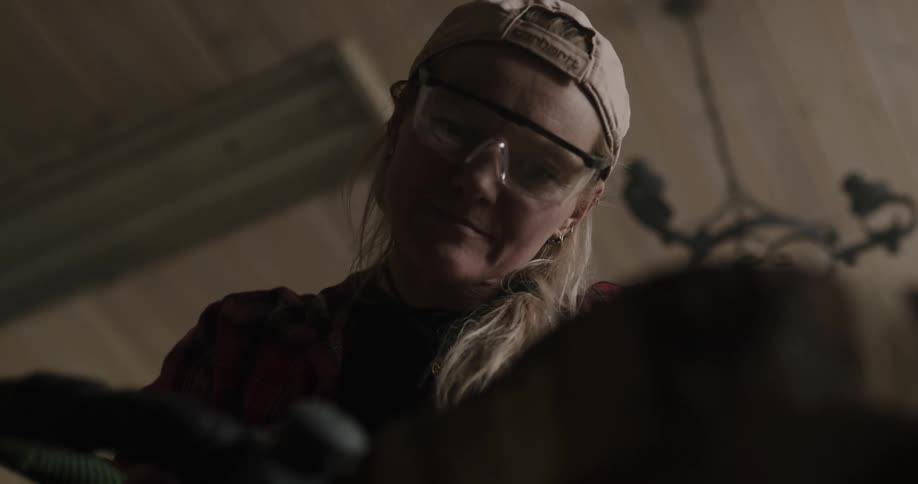 A woman sanding a piece of wood