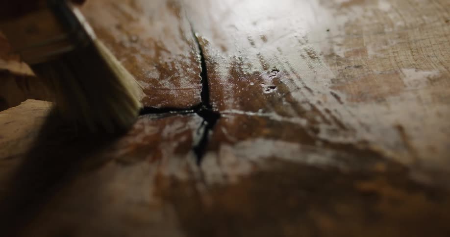 A woman stains wood