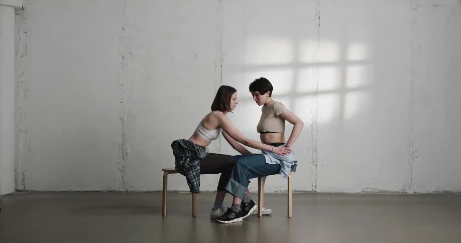 Women remove each others tops before hugging