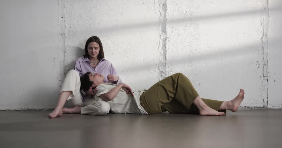 Young lesbian couple relaxing on the floor of a room