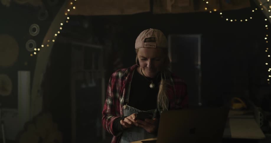 A woman takes a photo of a chair and then walks to her laptop and cheers