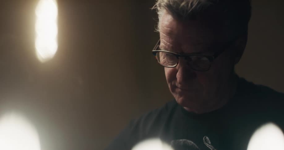 A man sitting in a room with lights on
