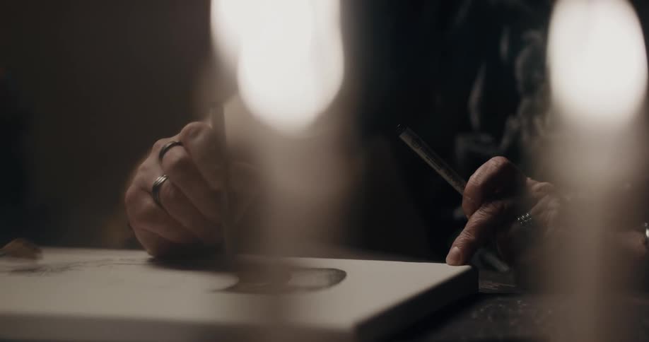 A man painting on a canvas on a table