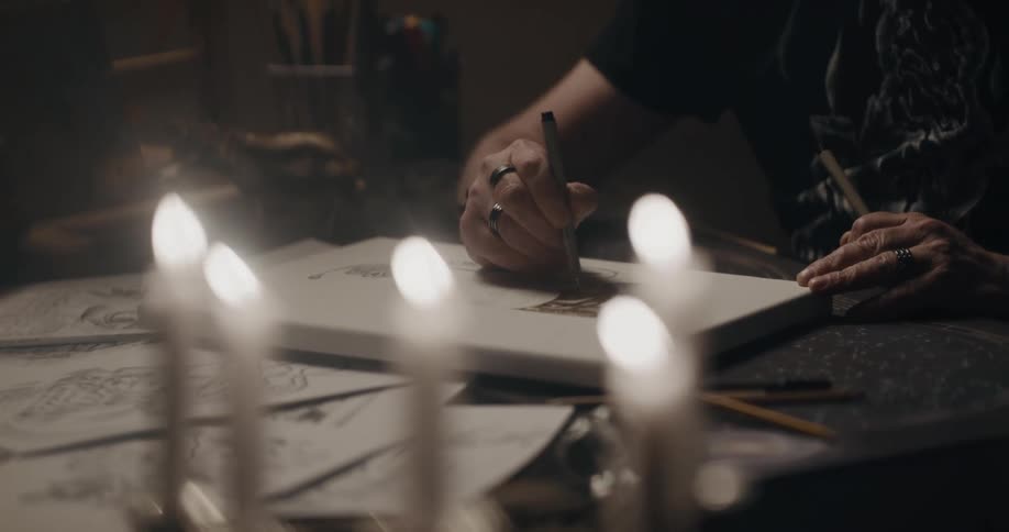 A person is sitting in a room and writing on paper