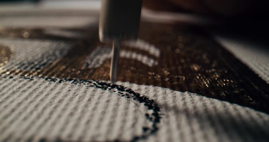A person using a tool to put ink on a fabric
