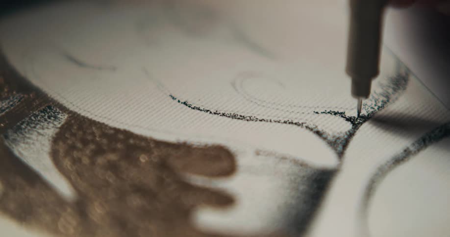A person drawing with a fine felt tip pen over paper