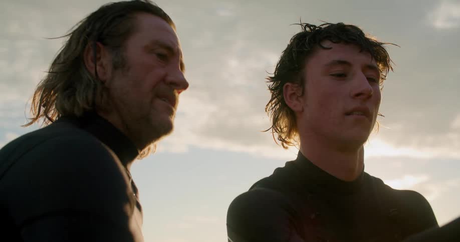 A father and son spear fishing on a beach in wet suits