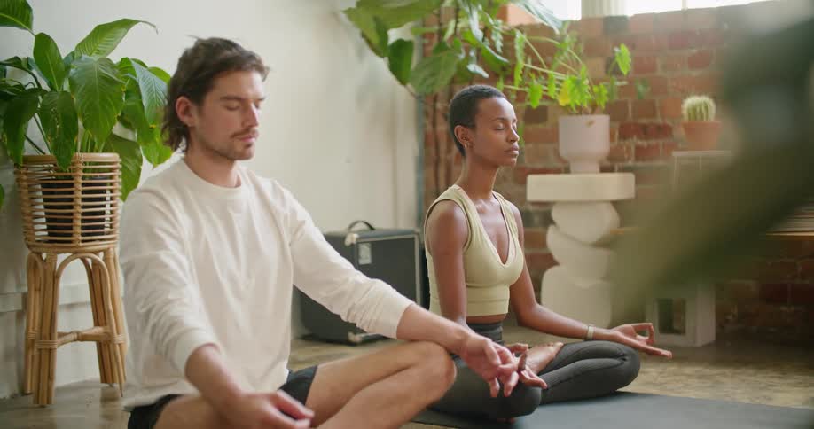 A man and woman doing yoga and meditating