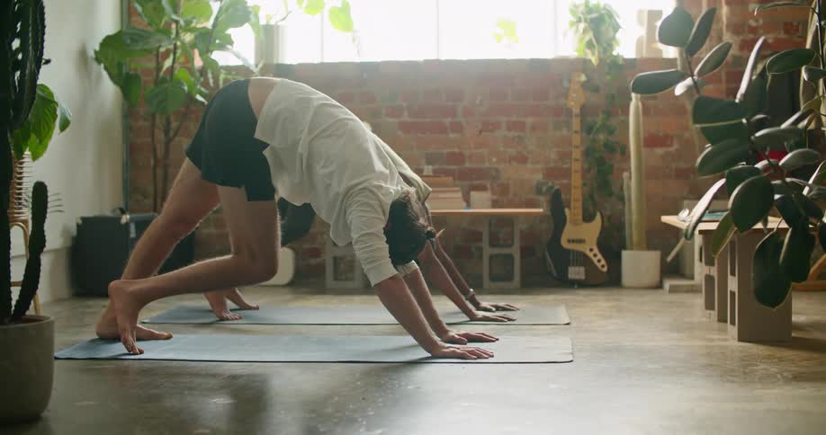 A man and woman doing yoga in a room
