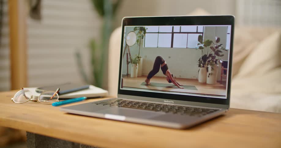 A laptop displaying an online yoga class