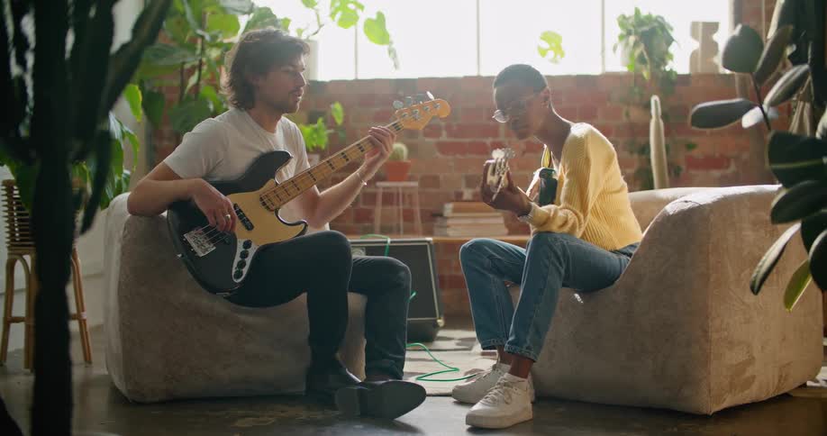 A man and woman are sitting in a room and playing guitar