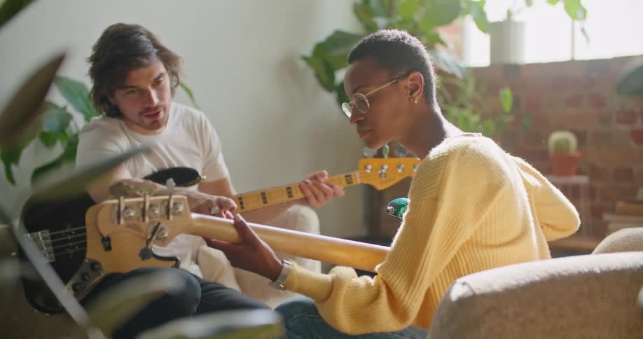 A man and woman are playing guitar together