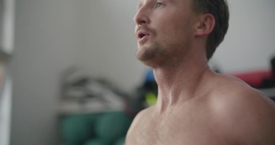 A man takes off a boxing glove and catches his breath