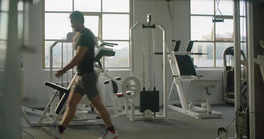 A man throws a towel over his shoulder as he walks out of a gym