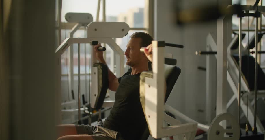 A man works out his arms and chest at the gym