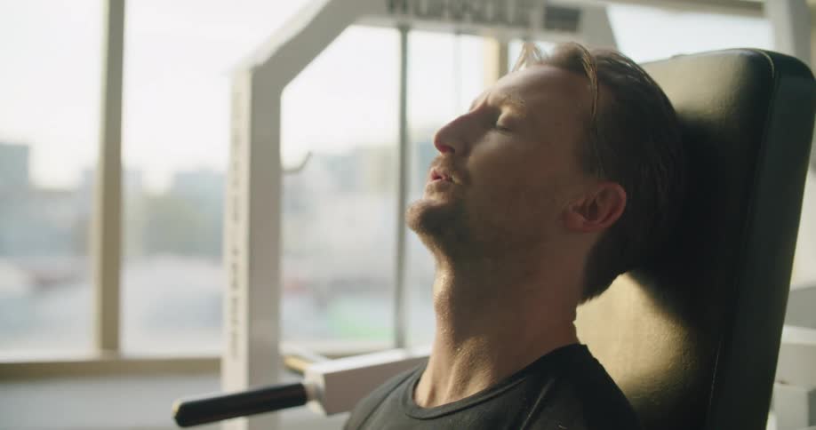 A man is working out in a gym next to a window