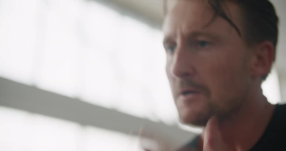 A man in a room sweating and breathing heavy