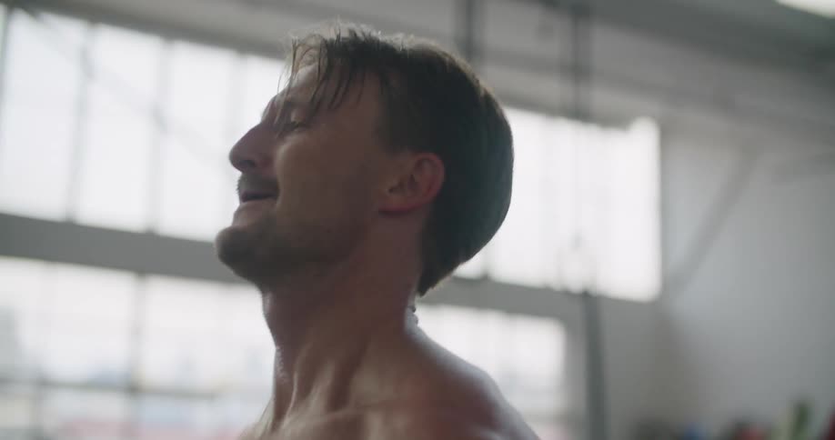 Muscular shirtless man weightlifting on a gym