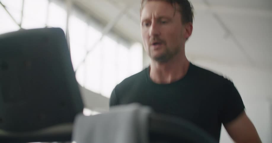 A man running on a treadmill in a gym