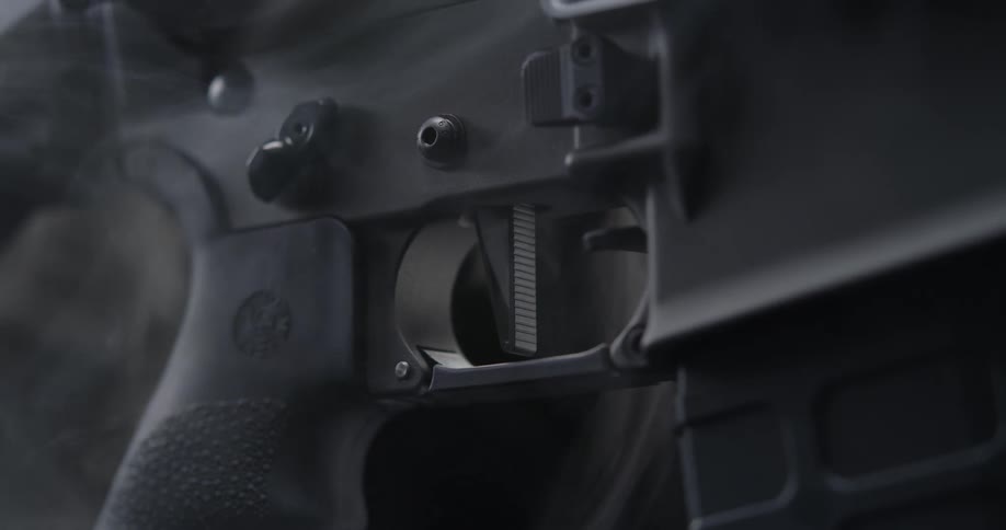Smoke surrounds a black rifle