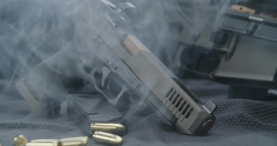 A view of guns on a table with smoke around them