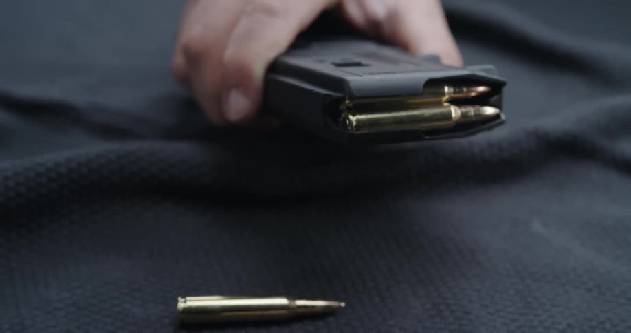 A person is loading rounds into a magazine