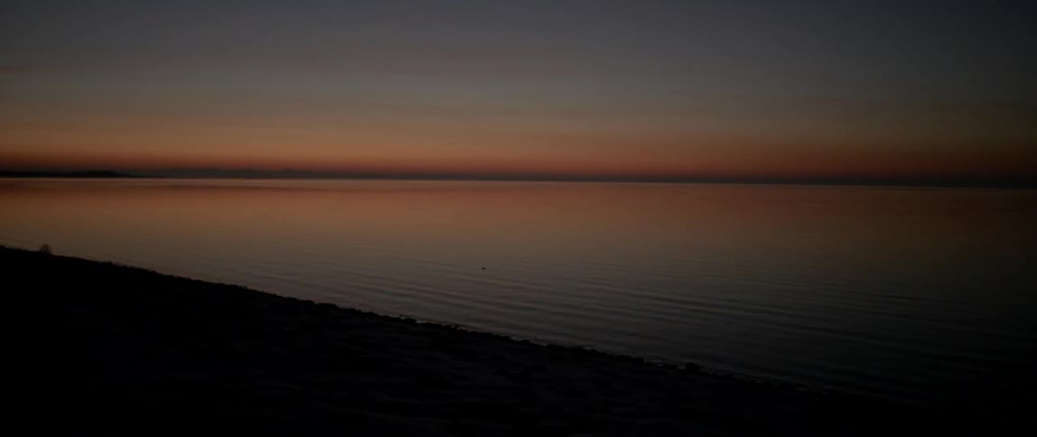 Calm body of water at sunset
