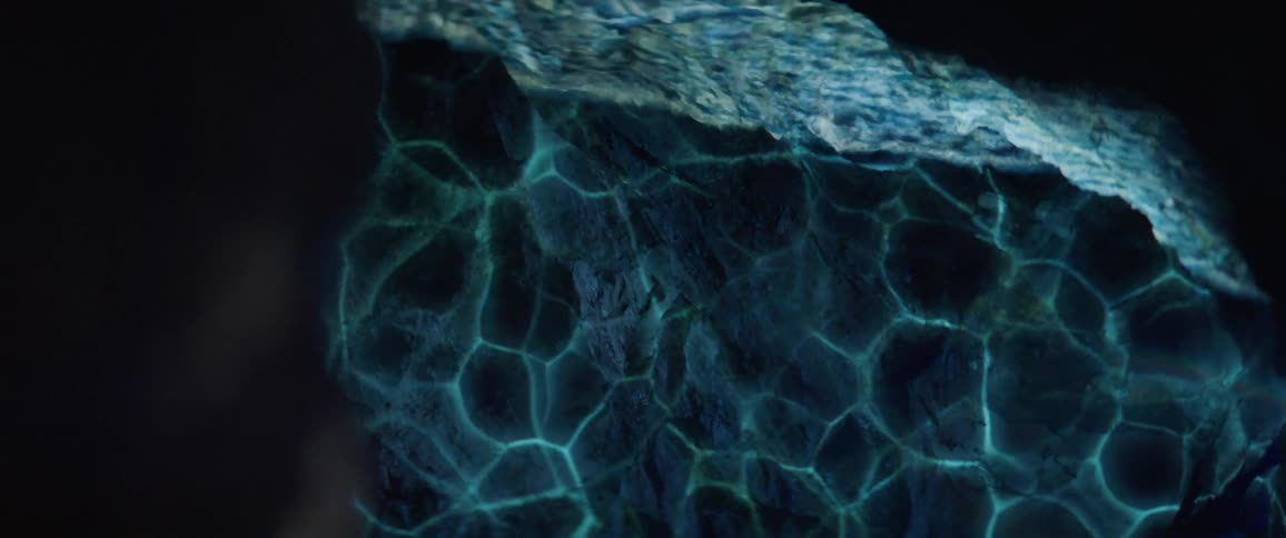 Ocean waves are projected onto a rock wall