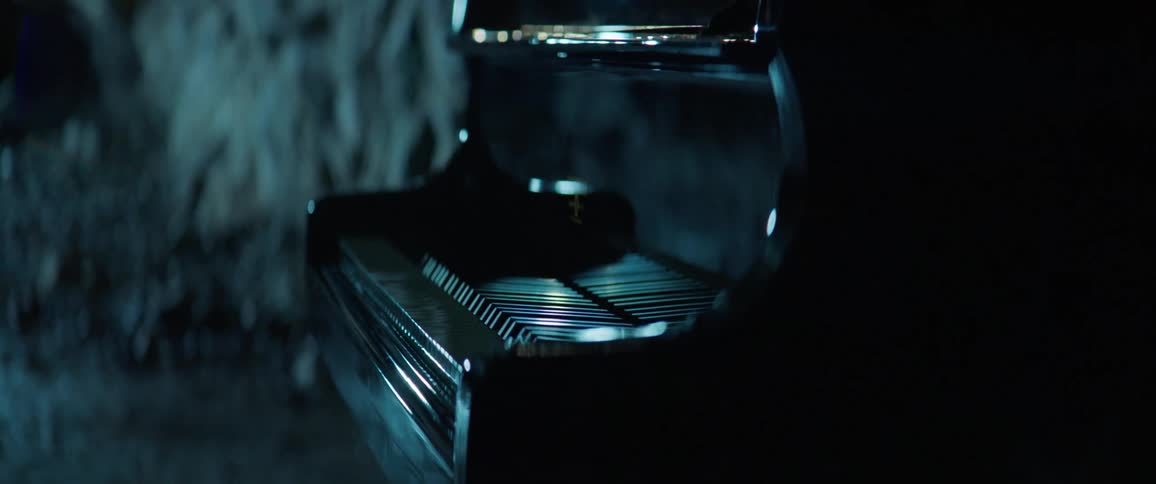 A piano sits in a dark room