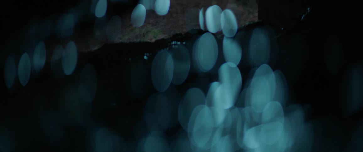 Lights shining on a wall and the inside of a cave