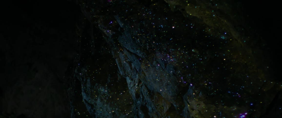 Lights shining on a wall and the inside of a cave