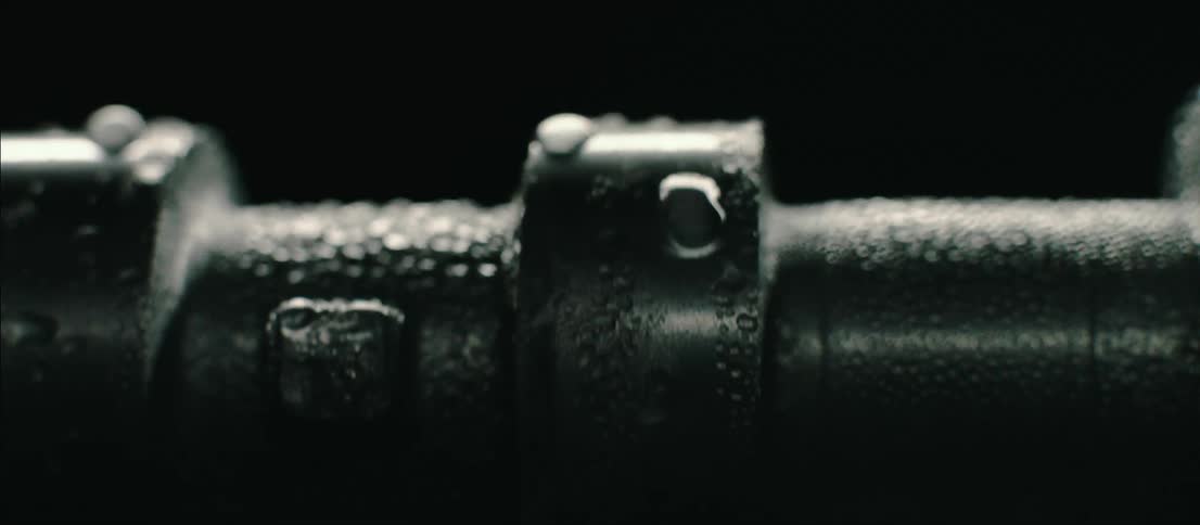 A rotating cylindrical piece of machinery covered in water droplets
