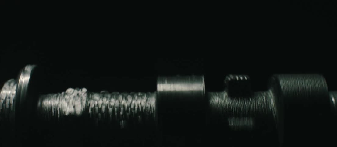 Engine shaft spinning inside a dark room under flashing lights