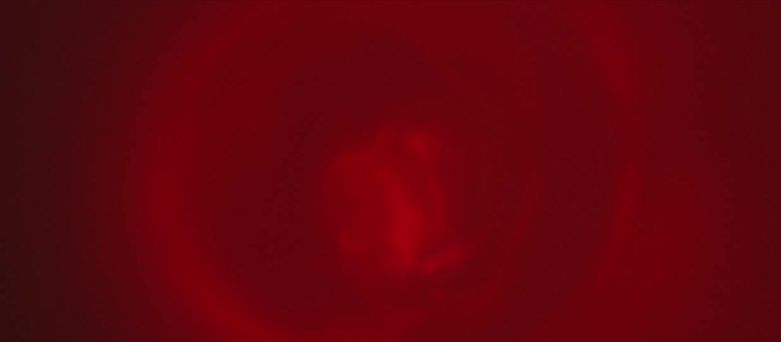 Light shines blindingly from swirling crimson liquid briefly before fading leaving area in darkness again