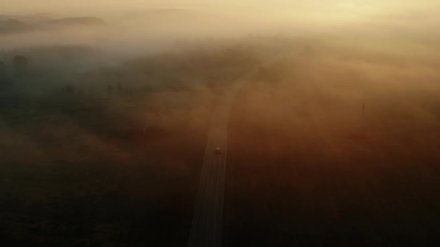 Sun rising in the distance on a misty morning over a highway