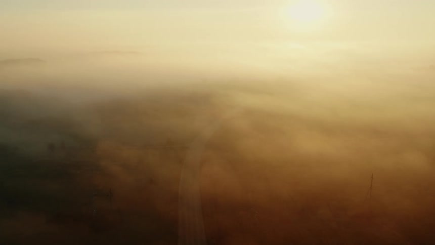 Aerial view of a road on a rural countryside under the fog in the morning