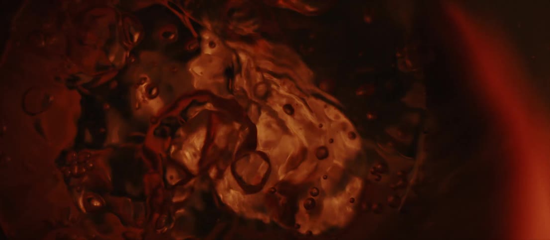A liquid is bubbling and lighting makes colors appear on the liquid