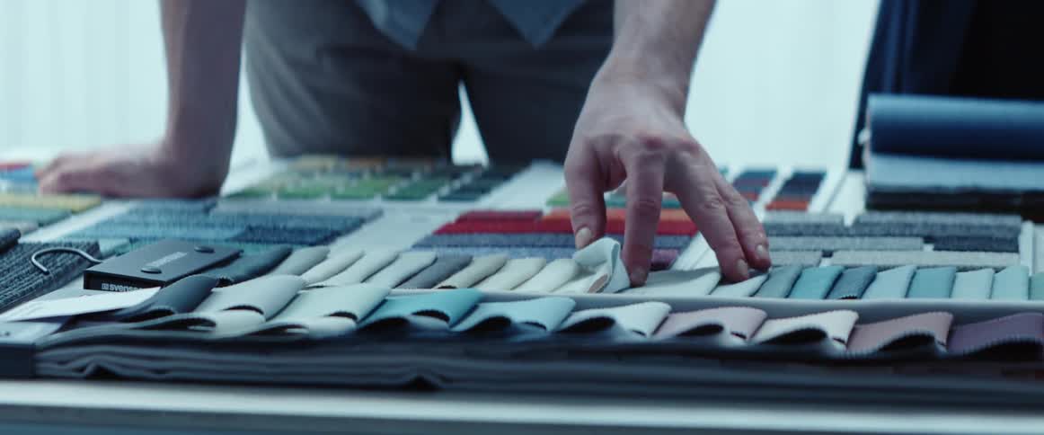 A person is looking at different pieces of fabric