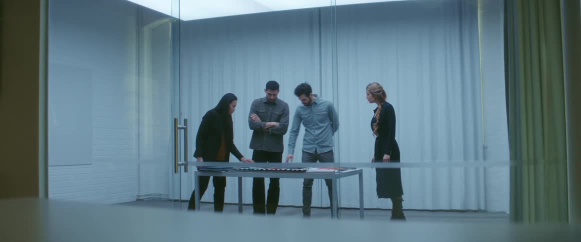 Group of people standing on a meeting room inside an office looking at samples