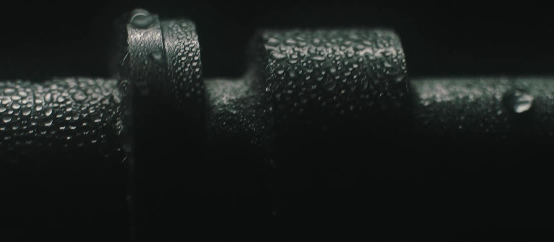 Dark metallic wet barrel with variable diameter sections turns as area brightens