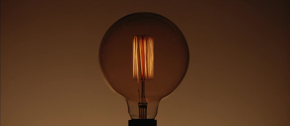 A light bulb flashing on and off in an empty space