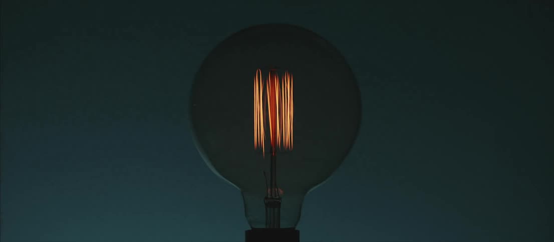 Yellow bulb filaments turning on inside a dimly lit room