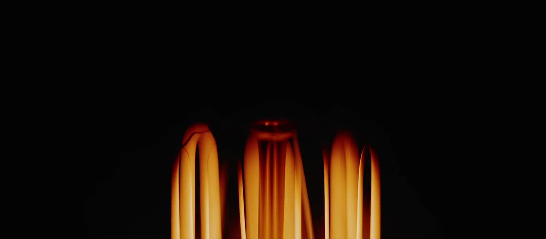 Yellow bulb filaments turning on inside a dimly lit room
