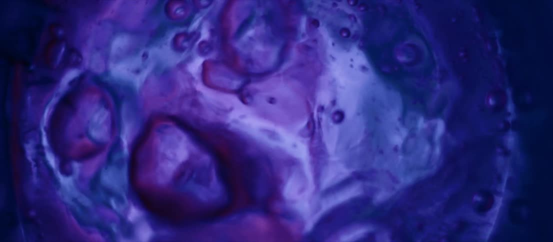 Artistic footage of liquid bubbling as lights change colors