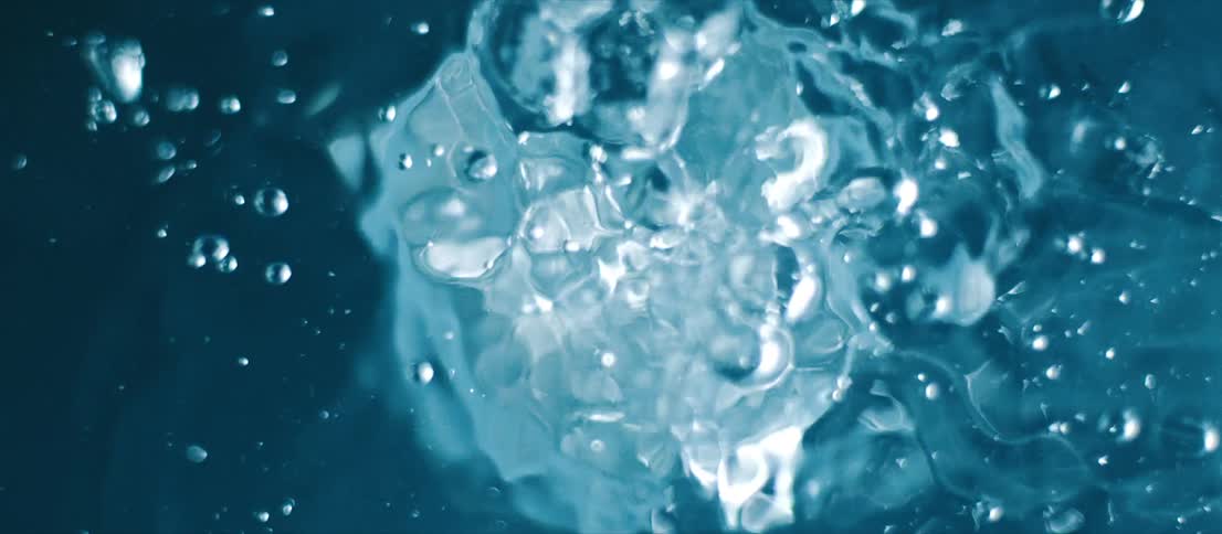 From underneath the surface of clear water more water is poured down into it