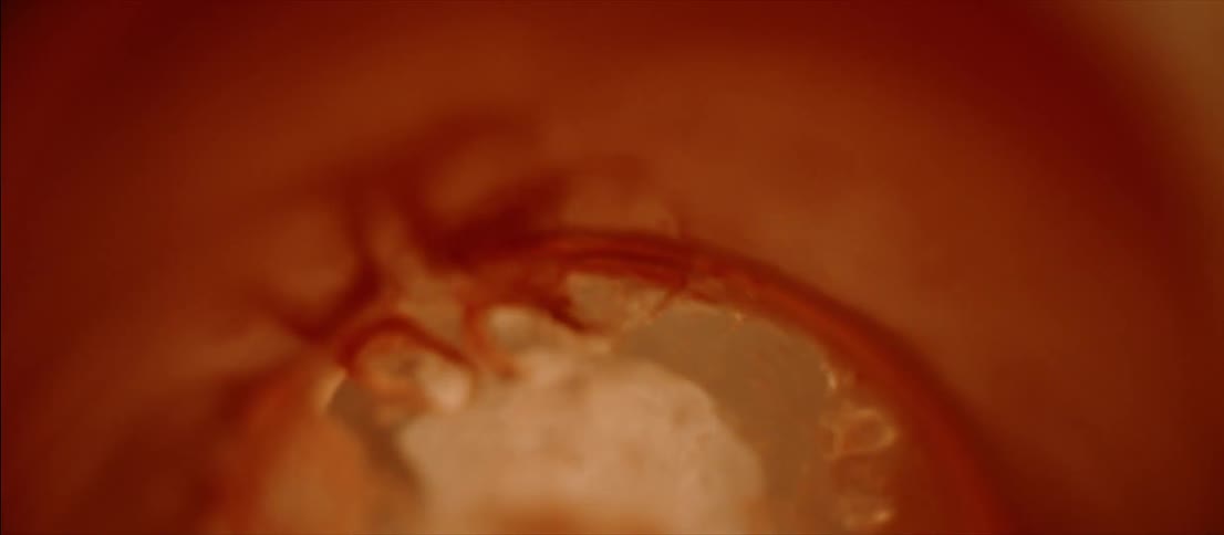 Clear liquid bubbling inside a metallic bowl reflecting flashing colored lights