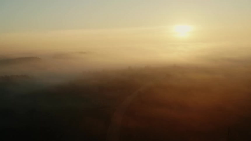 Aerial view of a road on a rural countryside under the fog in the morning