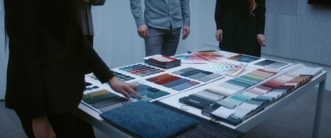 A group of employees gather around a table with product samples